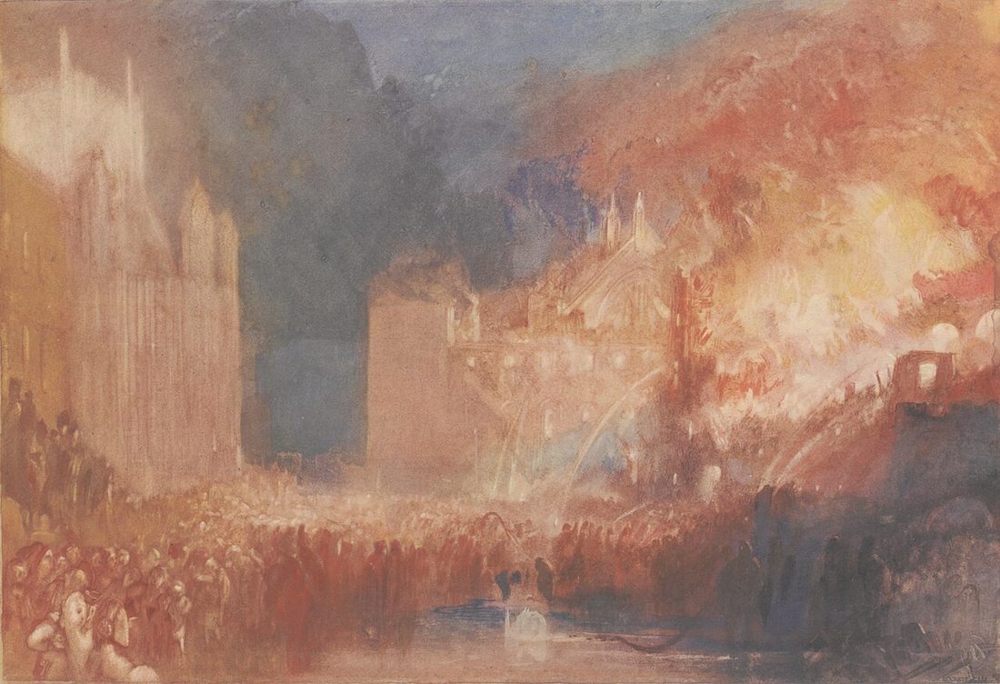 The burning buildings blaze red and white behind a dense crowd on the riverbank.